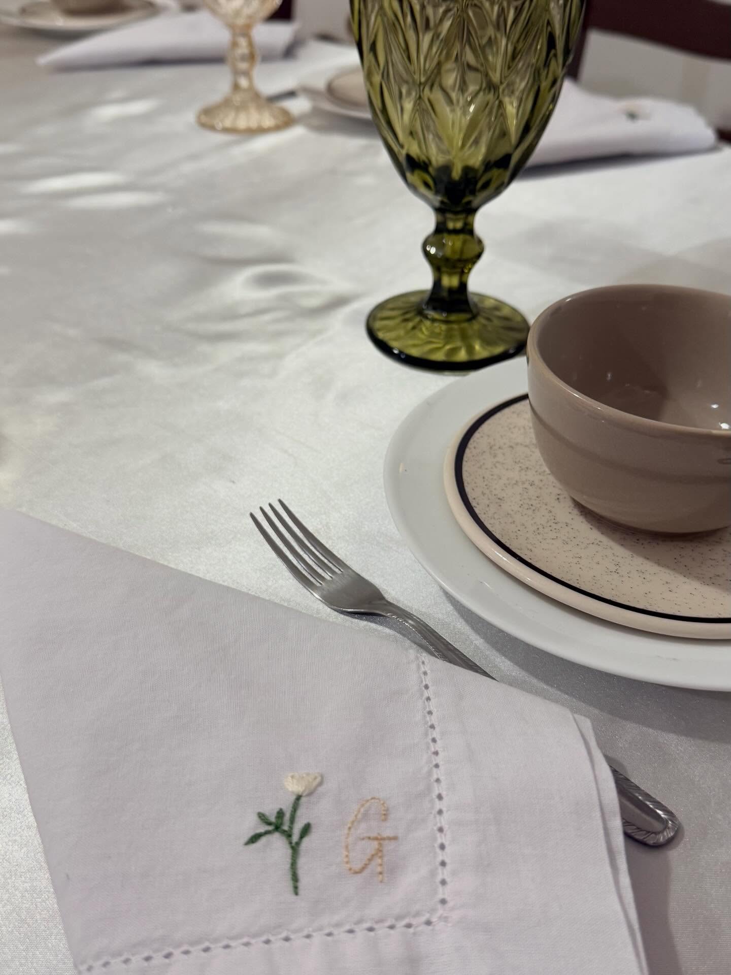 Guardanapo de mesa com flor delicada bordada em tecido branco