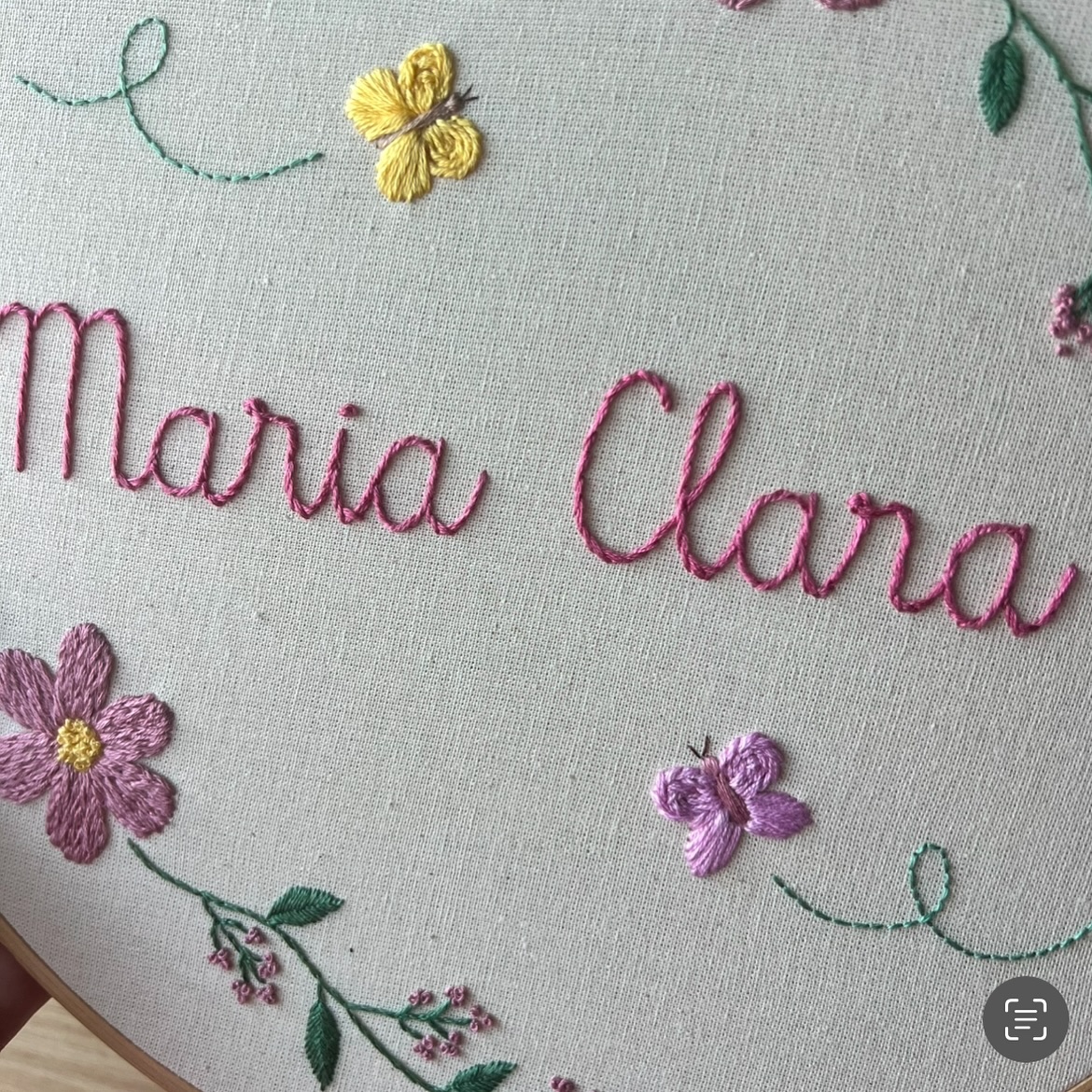 Detalhe de bordado floral com o nome Maria Clara