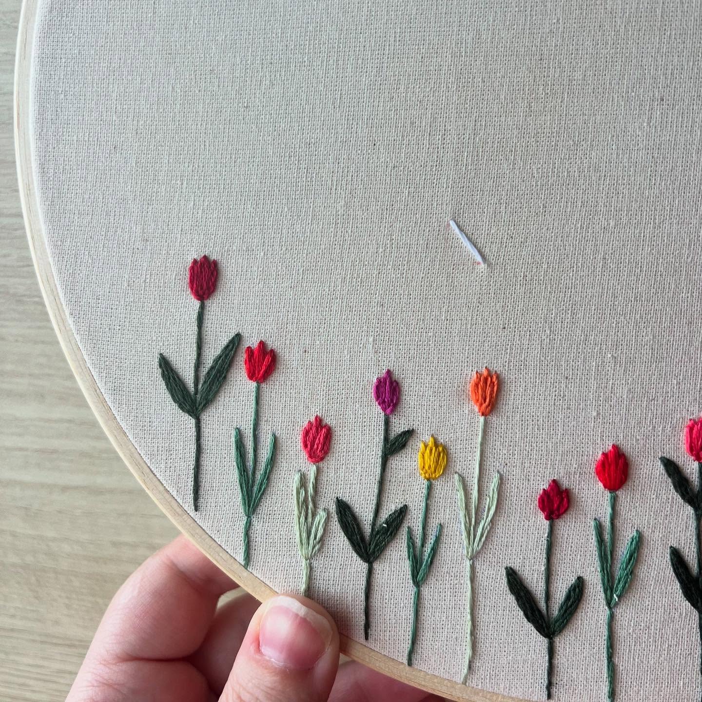 Detalhe de flores bordadas em tecido cru